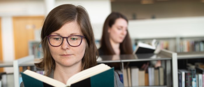 Two female students browsing in library