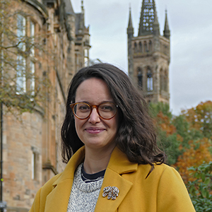 Profile photo of Helen Trail standing outside with the University of Glasgow tower in the background