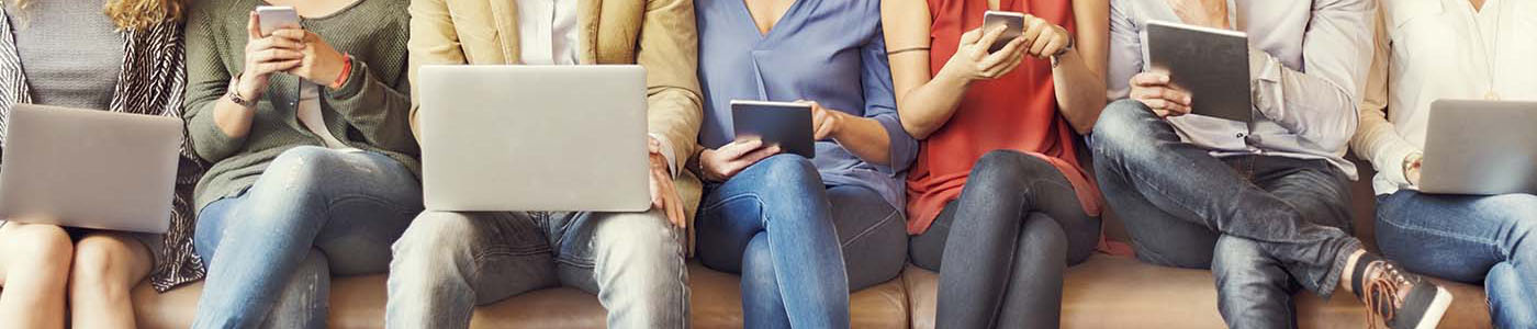 people sitting on a bench using mobile devices