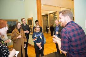 curator shows object to a group