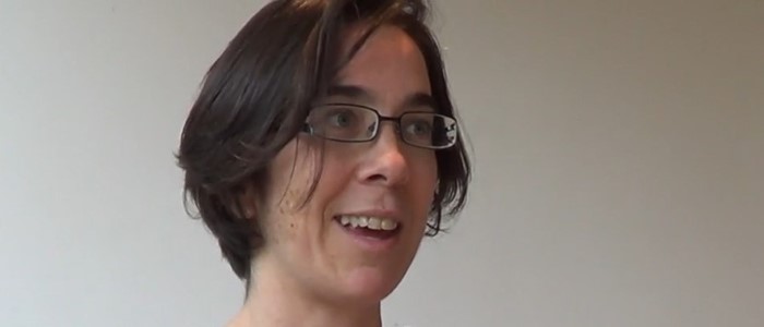 close-up photo of a young white woman with short hair and black tshirt, caught mid-sentence 