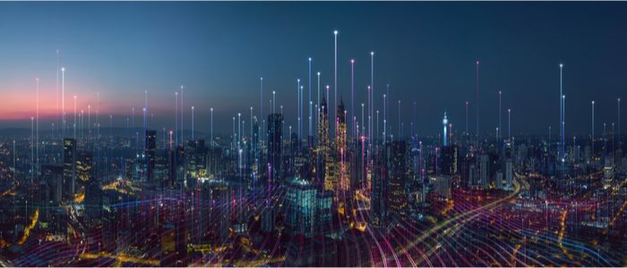 Abstract image of a smart city, with skyscrapers and brightly coloured lines to symbolise technological connections