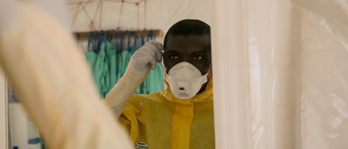 Massaqui putting on facemask during Ebola outbreak