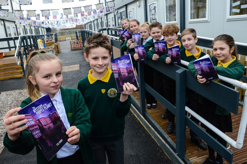 Primary school students holding copies of their novel
