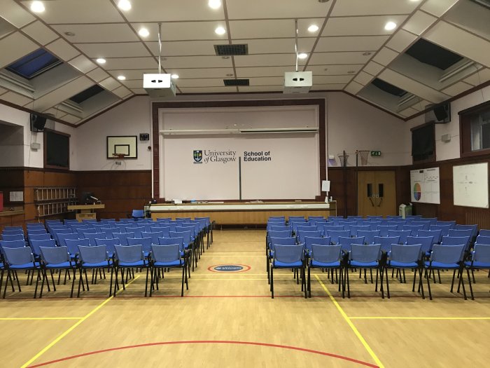 Flat floored gym with rows of chairs