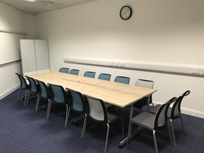 Flat floored teaching room with tables and chairs and movable whiteboards
