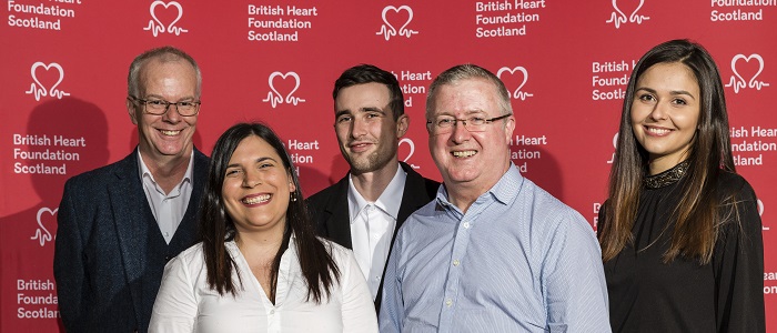 James, Martin & 4 year students in front of BHF logo background