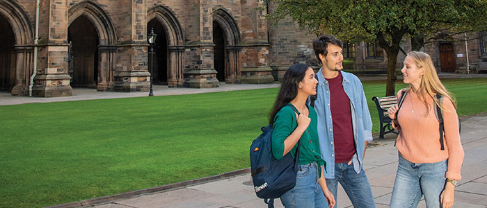 Three students standing in the quad