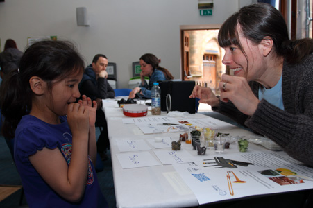 Photograph of a GSF volunteer with a child. The child is tasting different foods and categorising them based on main features e.g sour or bitter. 