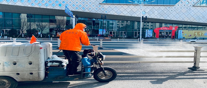 Zhenjiang, Jiangsu Province, China - February 01, 2020: A worker cleaning the streets with alcohol based solution with pressure. Disinfecting against to the Coronavirus