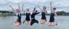 Five Glasgow University Boat Club members jumping at the edge of a pier