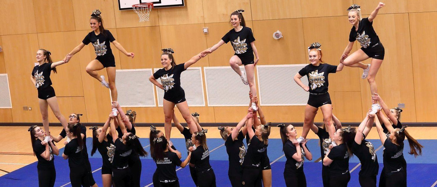 Members of Glasgow University Cheer doing a pyramid stunt