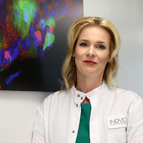 Scientist Kate Broderick in front of a colourful painting