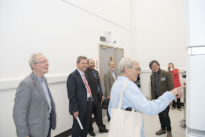 Dr Richard Henderson examines the electron microscope with other guests