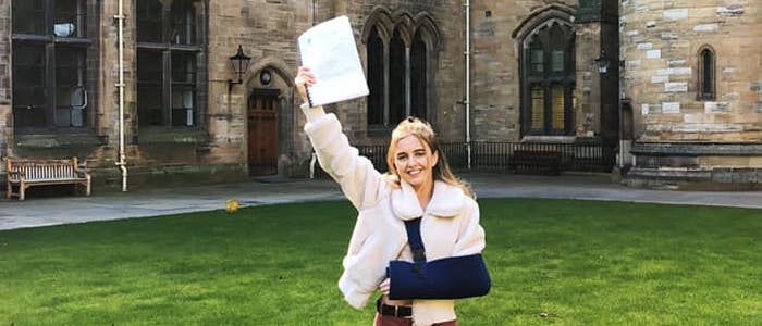 Catherine holds her dissertation in the air