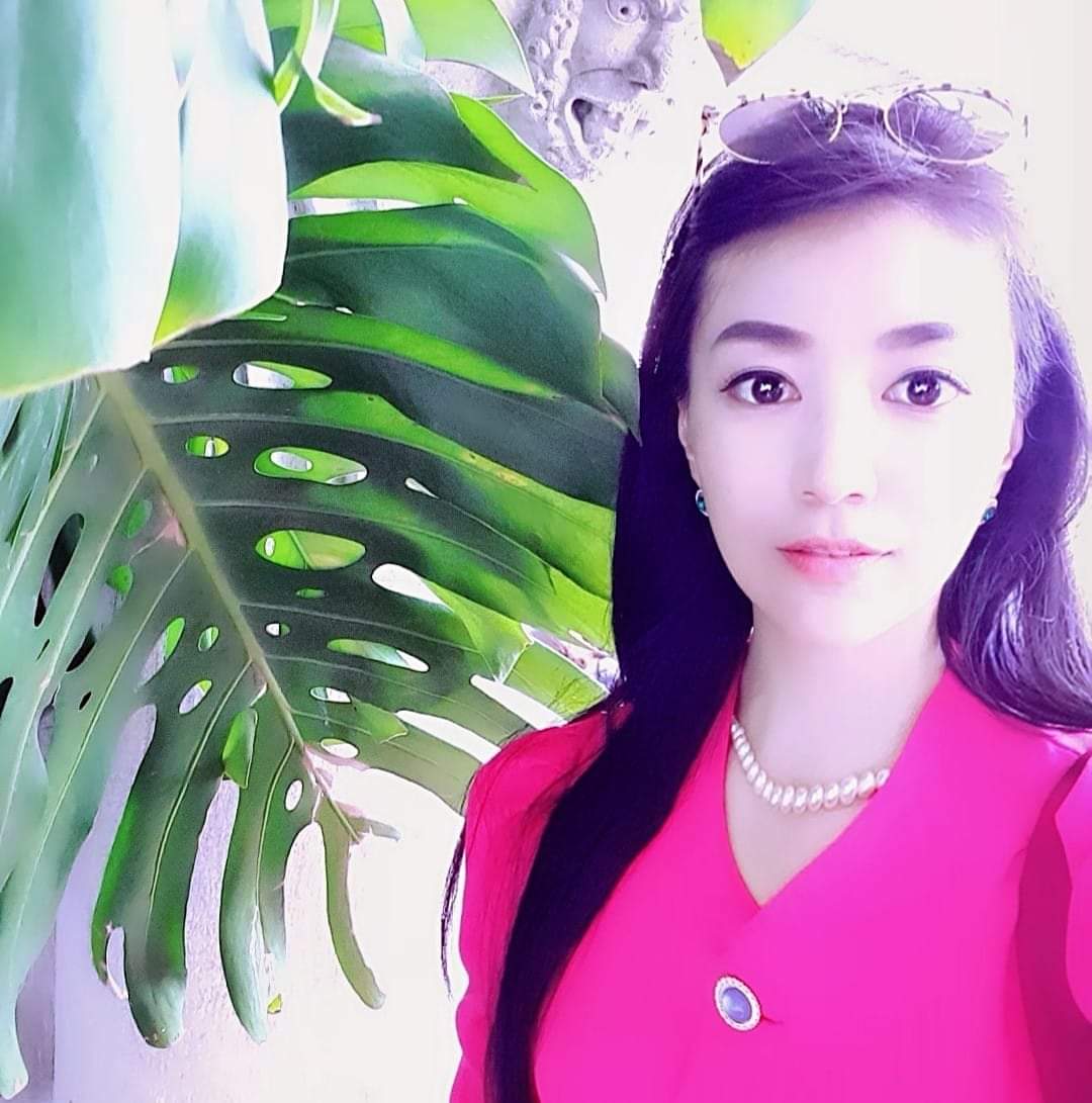 Image of SunHa Ahn standing by a plant