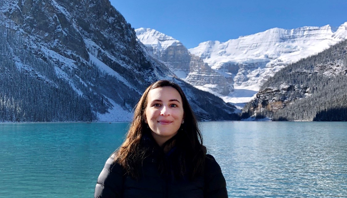 Student Kristina in front of majestic snow capped mountains at Lake Louise, Banff National Park, Alberta, Canada