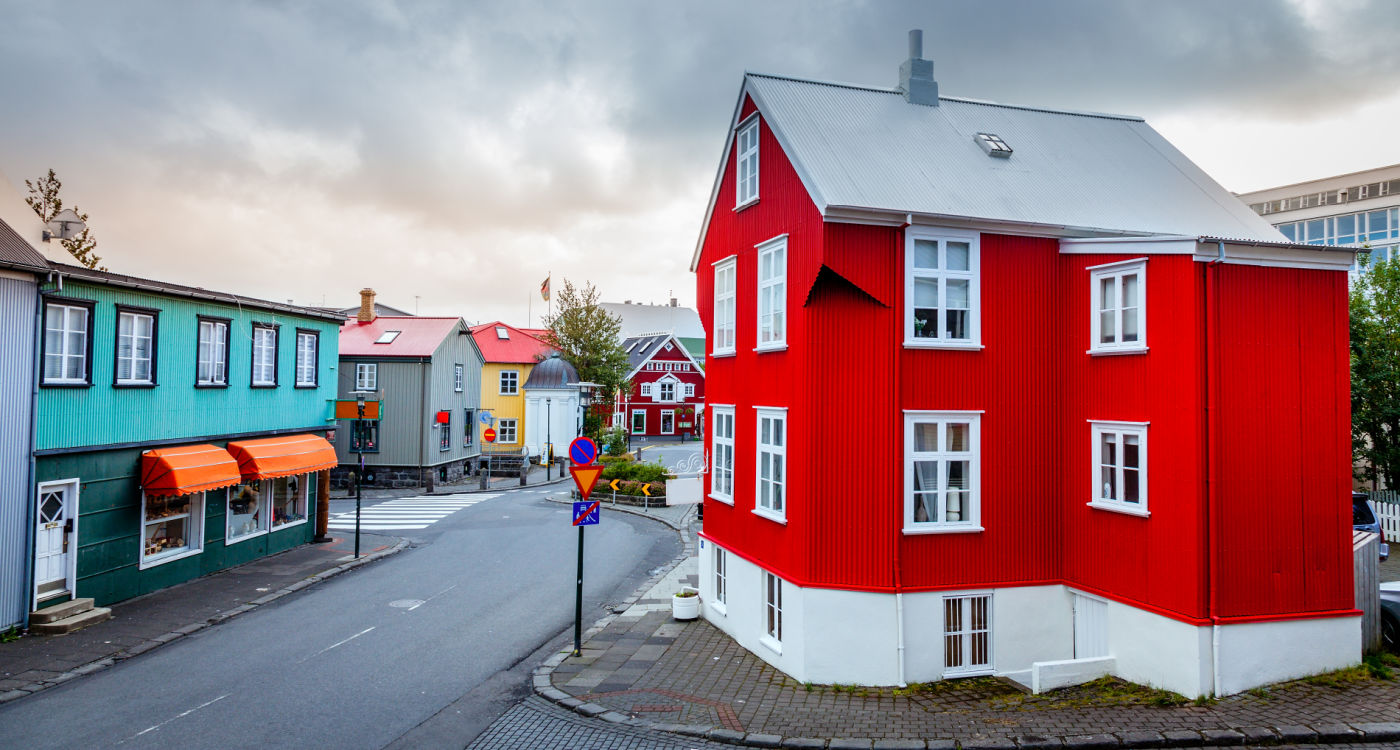 A street in central part of Reykjavik with a bright red house in the foreground.