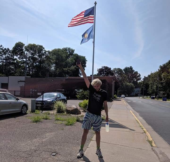Student Moray Swanson standing in front of a US flag