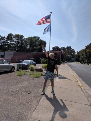 Student Moray Swanson standing in front of US flag