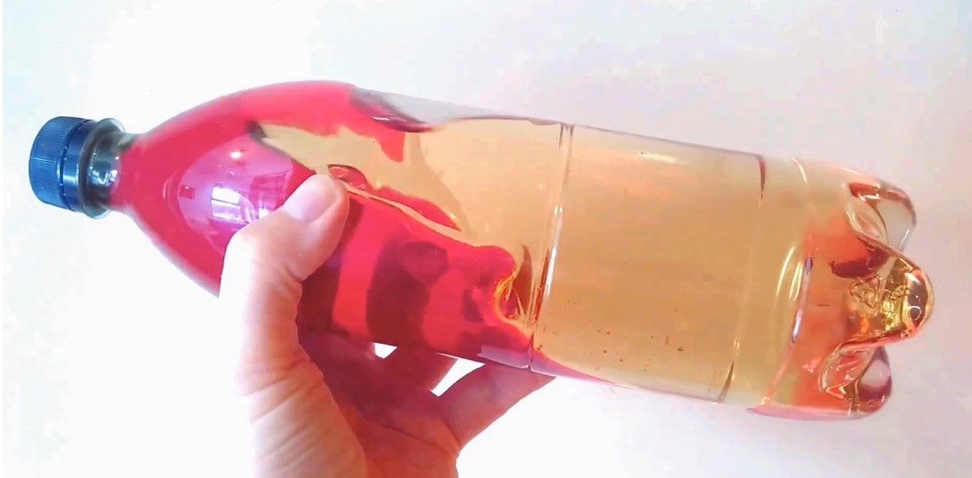 Bottle containing waves from coloured water and oil