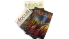 Three copies of infocus magazine fanned out on a white background