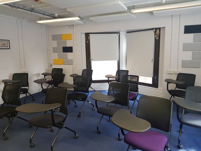 Flat floored teaching room with tables and chairs in a horseshoe set-up