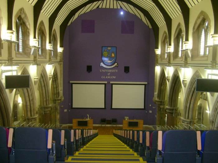 Raked lecture theatre with fixed seating, screens and video monitors