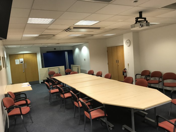 Flat floored teaching room with tables and chairs in round table set-up