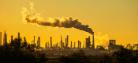 A chimney at an industrial complex releases smoke into the atmosphere