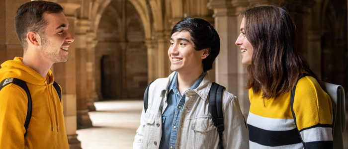Three students standing in the cloisters