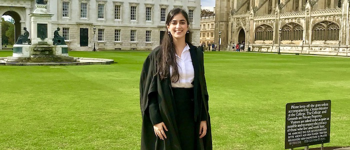 Young female graduate in front of Cambridge University lawns