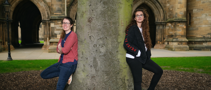 Aine O'Brien and Sara Motaghian, the organisers of the Roving with Rosalind education outreach programme, relax against a tree in the University of Glasgow quad 