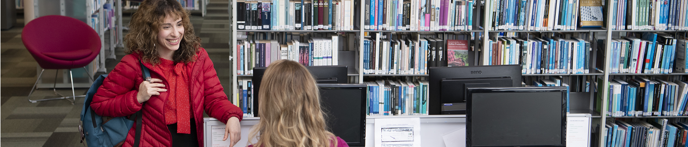 Two female students talking in the library