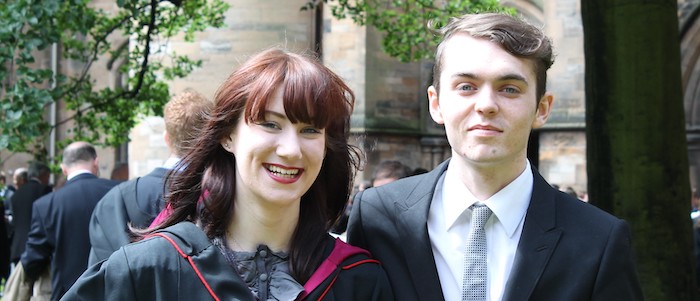 A young female graduate and young man smiling