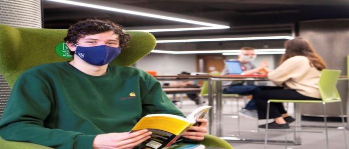 Student wearing a face covering in the library