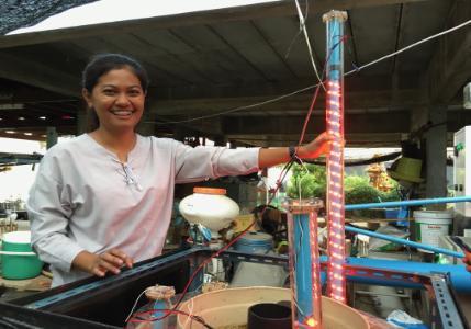 Researcher in Thailand with a wastewater bioreactor.