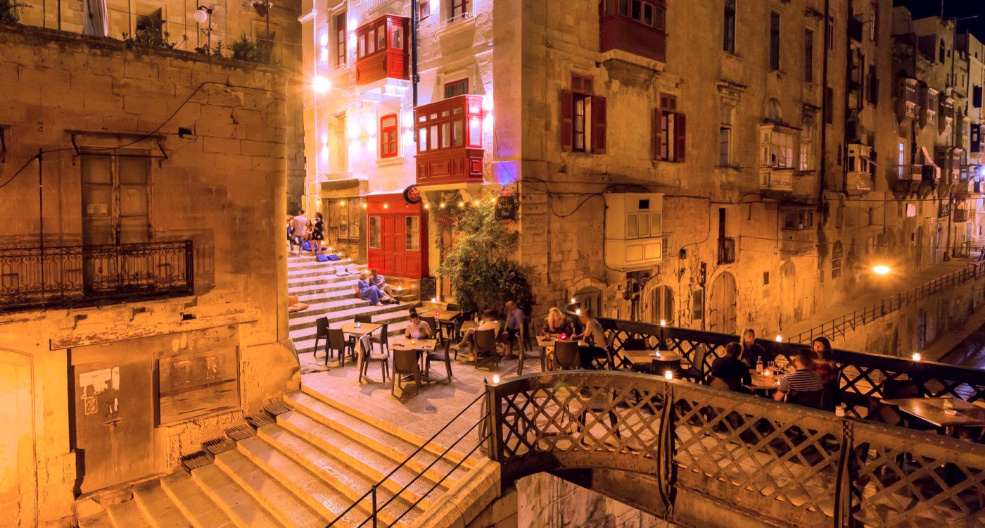 Evening view of the outdoor dining area on a bridge at The Bridge Bar, Valletta [Photo: Shutterstock]