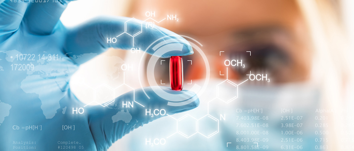 Female scientist holding a red transparent pill