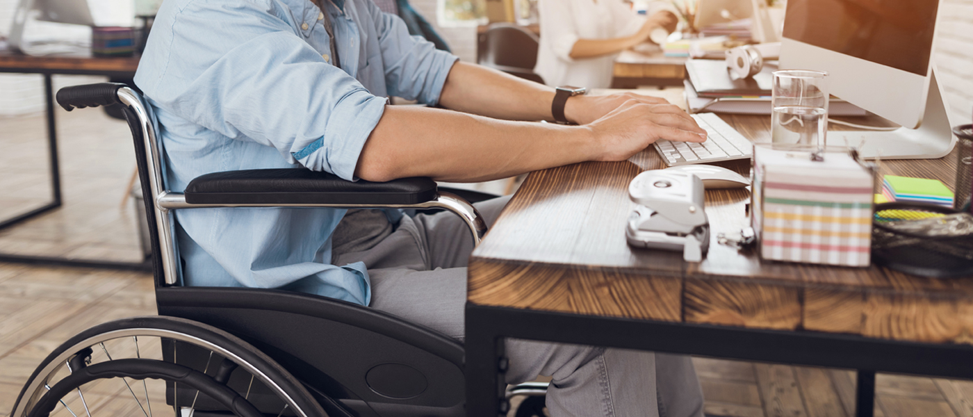 Photo of man in wheelchair using computer