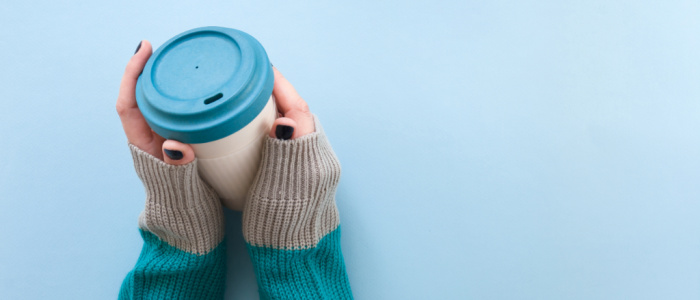Two hands holding a reusable cup