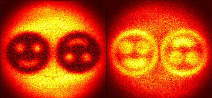 Two versions of a phase image of two smiley faces side-by-side, which are a selection from the four images combined to create quantum holographs