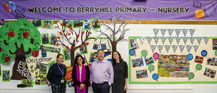 Staff members in front of welcome sign in Berryhill Primary and Nursery