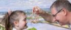 School pupil being shown a glass flask containing brown trout eggs a 