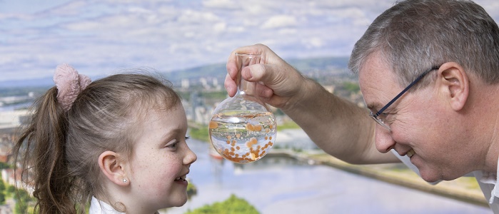 School pupil being shown a glass flask containing brown trout eggs a 