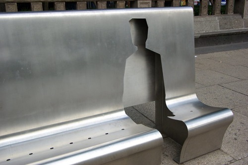 Metal street bench with figure cut out