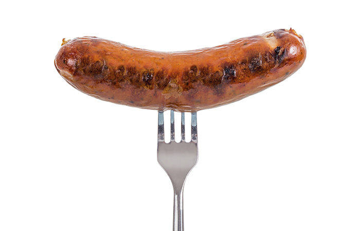 A cooked sausage on a fork