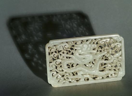 Jade; white nephrite belt plaque with water dragon, waves, clouds.