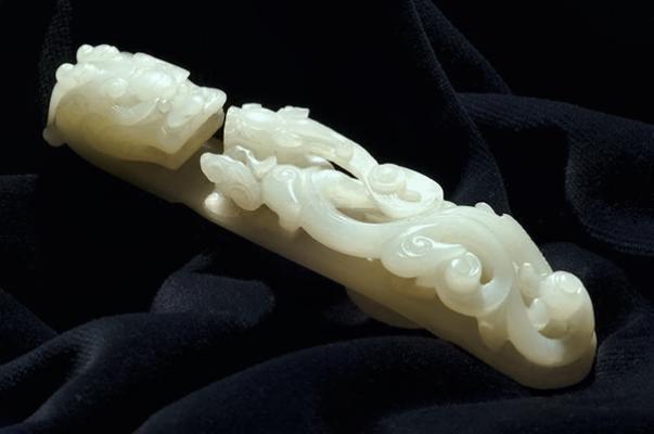 Jade; white nephrite belt hook showing Qi dragon with lingzhi fungus; carved on rear as well as front.