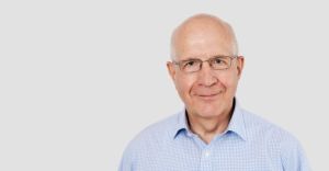 head shot of a man in a blue shirt 